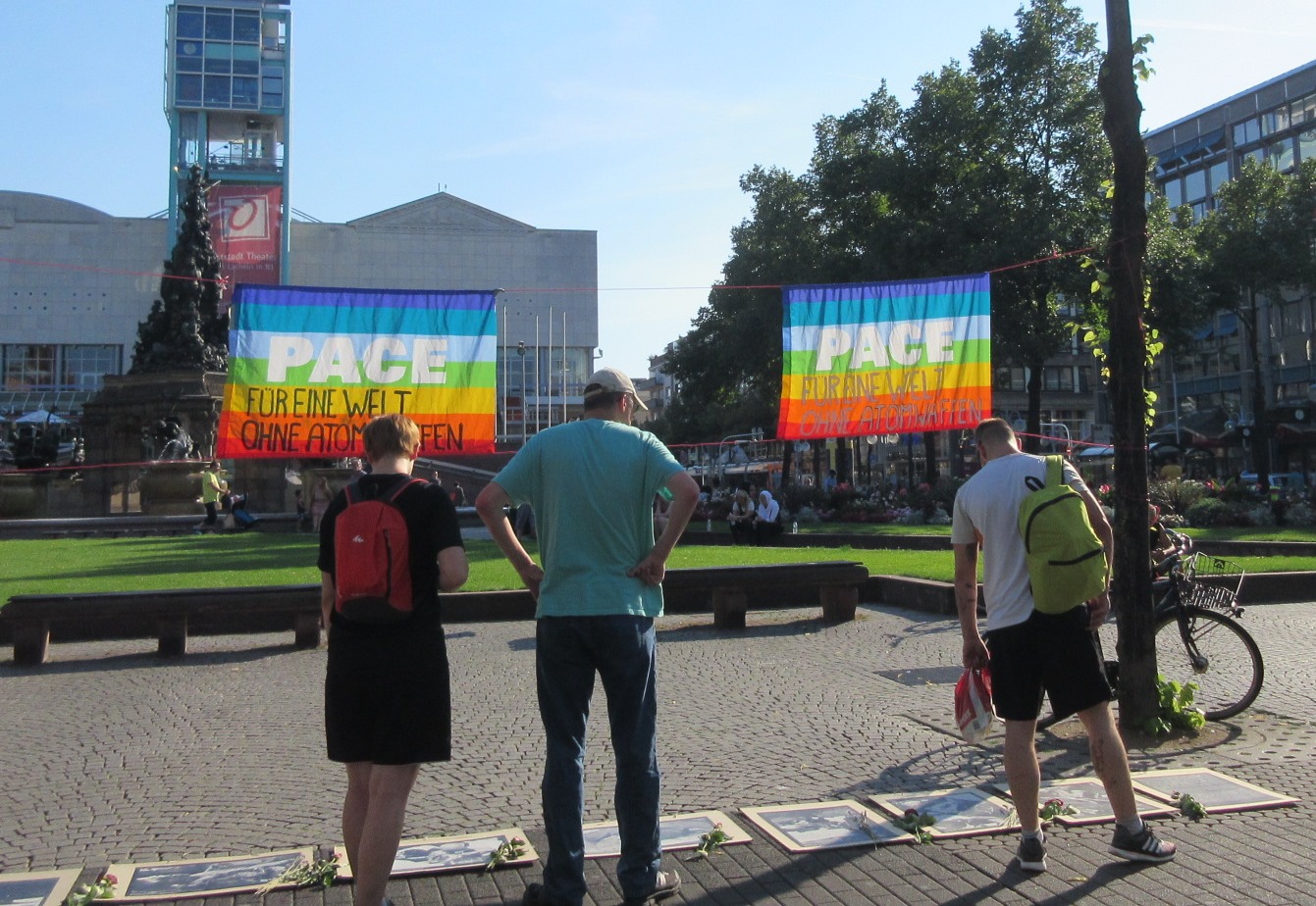 Betrachter der Fotos von Atombomenopfern bei der Hiroshima-Mahnwache am 6.8.2015 in Mannheim